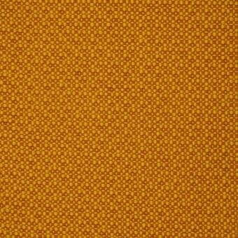 Mustard yellow fabric with a dense, nubby weave and subtle tonal variations, displaying a regular grid of raised dots in a studio setting.