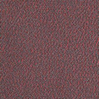Woven textile fabric, dark gray and red, displays a dense speckled pattern with a raised, nubby texture and consistent tight weave.