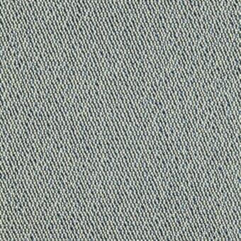 Beige fabric with a diagonal weave and dark blue speckles, exhibiting a granular looped texture; studio lighting, neutral background.