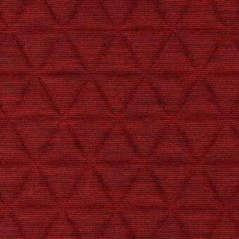Red geometric fabric sample featuring raised triangular quilting in a grid pattern, from the Lacividina Triangleumba collection.
