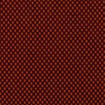 Reddish-brown woven fabric texture with repeating raised circular grid pattern, muted orange-brown highlights, consistent matte finish.