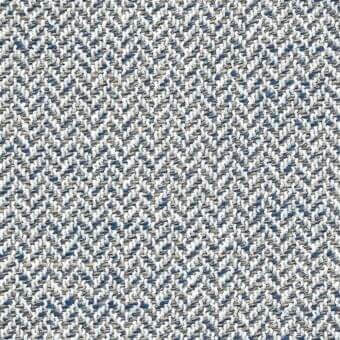 Herringbone fabric sample in white, blue, and beige tones displays a dense, nubby texture with a repeating chevron motif and subtle directional flow.