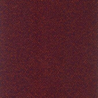 Burgundy fabric swatch with repeating small orange dot pattern, granular woven texture, matte finish, warm color palette, R438 col. 010.