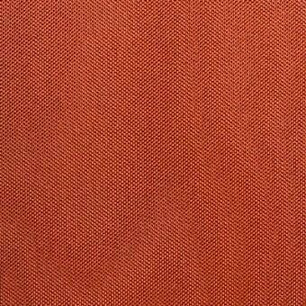 Reddish-orange woven fabric texture features a dense, repeating chevron geometric pattern; matte finish, structured weave for upholstery.