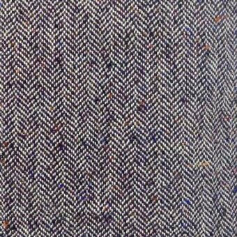 Herringbone fabric texture in deep plum with orange, blue, and cream flecks, featuring alternating diagonal weave lines and a speckled pattern.