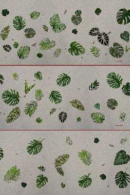 Fabric swatches with tropical leaf pattern in green shades, distressed texture, on beige background; textile sample collection detail.