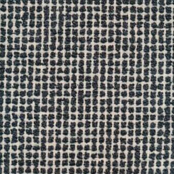 Woven textile sample, muted gray and cream, features irregular dark gray dots in a grid pattern over a cream base with a nubby matte texture.