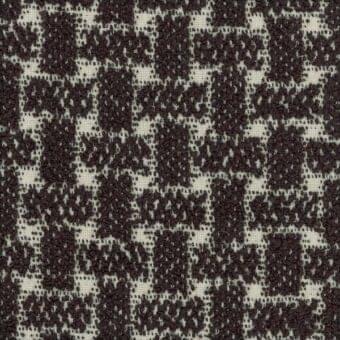Brown tweed fabric sample with irregular woven pattern, dense texture, and beige threads; wool or wool-blend composition with a dynamic, distressed look.