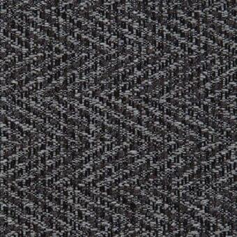 Charcoal gray woven fabric sample displays a dense, irregular herringbone pattern with a slightly nubby texture; part of Porada’s ikat collection.