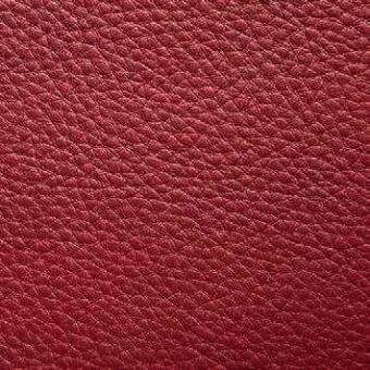 Red leather texture sample, Presotto “xt nhy55031”, displays a granular, pebbled surface with a matte finish and consistent pattern.