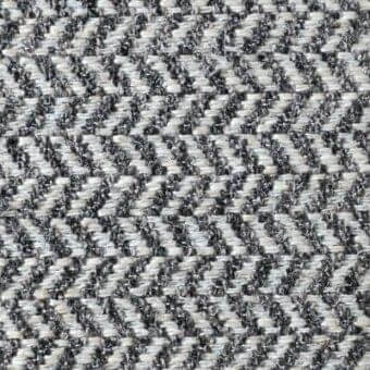 Herringbone fabric texture in fuscous, gray, and off-white tones displays a dense weave with subtle slubs and integrated “reflex” and “ginevra” text.