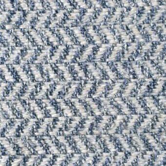 Herringbone fabric texture in light gray and muted blue tones, displaying a dense weave with “Reflex,” “Ginevra,” and “Danube” labels.