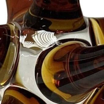 Murano glass sculpture, amber and brown, swirling organic form with layered curves, etched fan detail, glossy finish, white background.