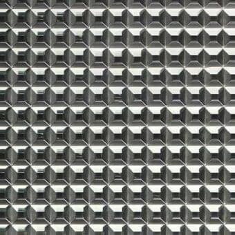 Diamond-patterned glass texture in shades of gray and silver, featuring a repeating grid of small, faceted elements with reflective qualities.