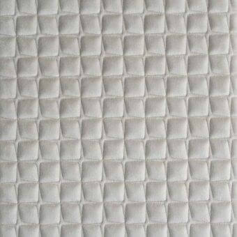 Quilted fabric texture features a repeating light gray rhomboid pattern in a grid, with visible stitching and a matte finish.