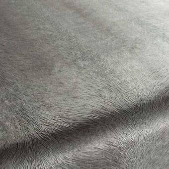 Gray Rugiano rug with dense, sheared texture and short pile, displaying subtle tonal variations and a gently curved, folded shape.