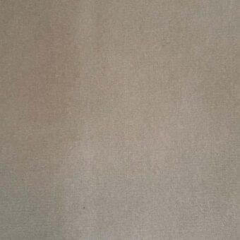 Beige area rug with a dense, woven fabric texture and consistent nap, displaying a solid, neutral color and minimal surface variation.