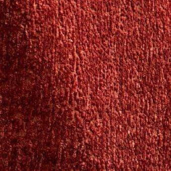 Terracotta rug with dense, textured pile displaying warm, muted tones and granular surface variations; indoor textile element.