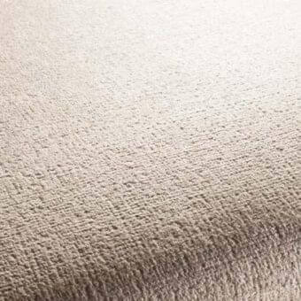 Beige rug with short dense pile, exhibiting a uniform weave and subtle mottled texture, in a warm neutral taupe tone with a matte finish.
