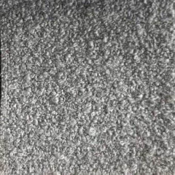 Gray rug with dense, short fibers exhibiting a medium gray tone and subtle tonal variations in a uniform, plush texture.