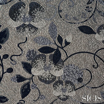 Sicis Dolium Blue mosaic fabric displays floral and vine motifs in gray and black tesserae, with a textured, three-dimensional pattern and SICIS branding.
