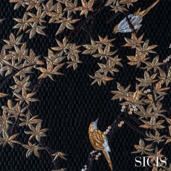 Fabric design with embroidered maple leaves in gold, bronze, and copper tones, featuring blue and yellow birds on a dark gray textured background.