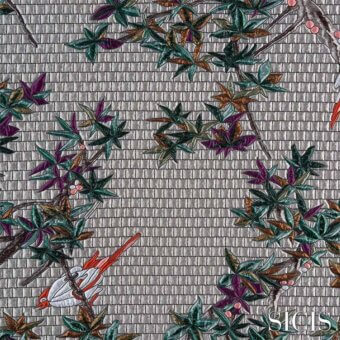 Fabric design with maple branches, birds, and embroidered purple, green, brown, and orange leaves on a textured gray grid background.