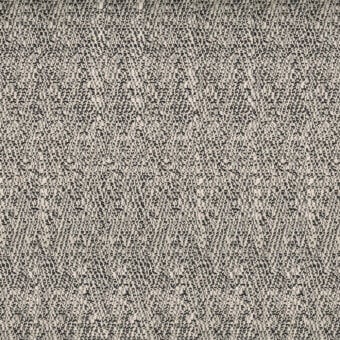 Beige and dark brown woven fabric sample displaying a dense, speckled texture with irregular shapes and a matte finish.