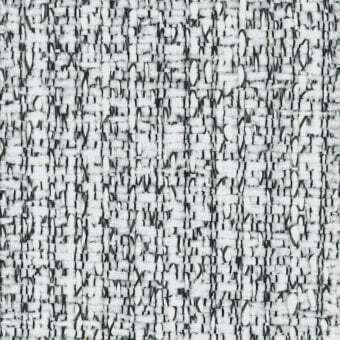 Woven fabric sample, white and gray tweed, dense irregular nubby texture with speckled pattern and visible “turri” label.
