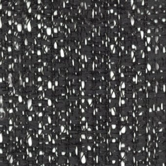 Black and white tweed fabric texture with a dense, irregular weave and nubby fibers; brand marking “turri > fabric cat. b > 775 e” visible.