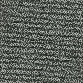 Woven fabric sample, muted gray and off-white, dense speckled texture with visible knots; rectangular label reads "turri > fabric cat. t > 779 e".