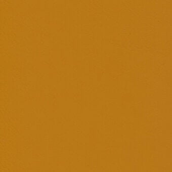 Mustard yellow matte surface displaying a uniform, granular texture with even lighting and a flat, consistent plane throughout the composition.