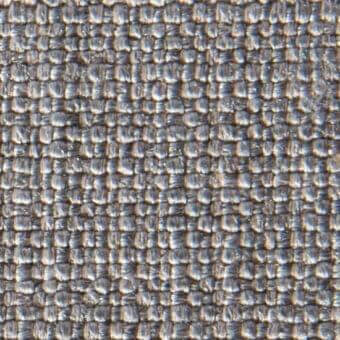 Gray woven textile fabric sample with irregular nubby texture, displaying silver and charcoal shades; product label visible.