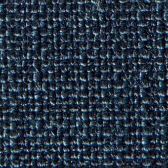 Dark blue woven fabric sample with a grid pattern, featuring repeated “verzelloni” text and identifiers within the textured surface.