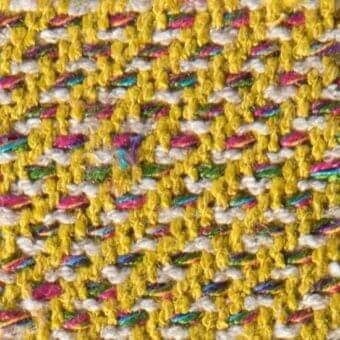 Woven fabric texture, mustard yellow and off-white horizontal bands, with pink, blue, green, and silver threads; matte finish.