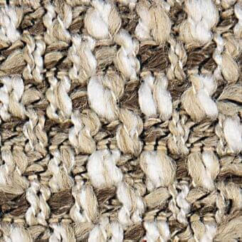 Woven fabric texture, cream and beige tones, irregular looped pattern, natural fiber blend, visible “verzelloni” textile label, detailed close-up.