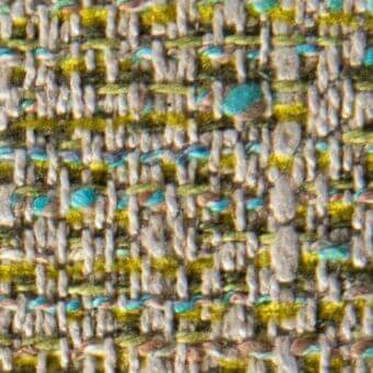 Woven fabric texture, muted gray with yellow and turquoise accents, irregular pattern with raised nubby surface and subtle sheen.