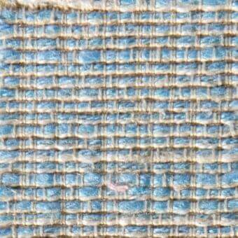 Woven fabric texture displays muted blue and beige grid pattern with embedded labels reading “verzelloni” and “steven 16018”, matte finish.