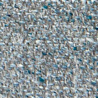 Woven textile with irregular gray and blue fiber pattern, displaying embedded text “verzelloni,” “fabric,” “liam,” and a granular texture.