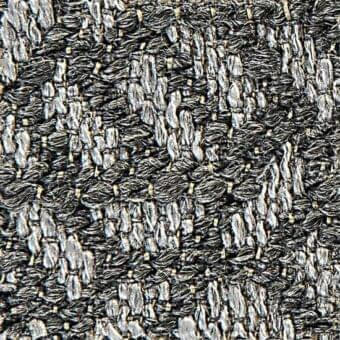 Black and silver-gray tweed fabric texture with irregular, chunky weave and nubby surface; vertical and horizontal yarn structure.