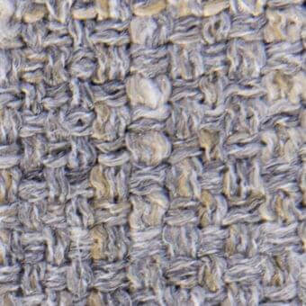 Woven fabric texture, muted gray and sandy beige, irregular heathered pattern with a nubby, matte finish and distinct vertical-horizontal grid.