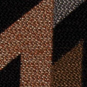 Textile pattern with intersecting metallic copper and silver woven bands on black fabric, displaying varied textures and diagonal composition.