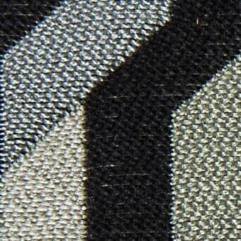 Diagonal fabric texture split between light gray woven textile and dense black material, separated by a dark gray band.