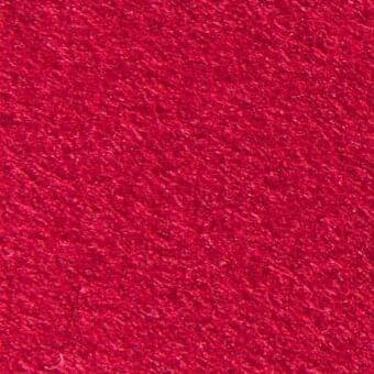 Red woven fabric texture with a dense, fibrous surface and matte finish, displaying a granular appearance with a dark thread detail.