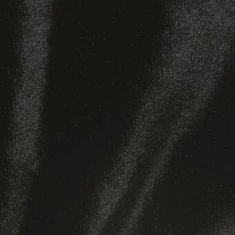 Distressed black texture with speckled light gray overlay, featuring diagonal streaks and granular particles creating depth and visual noise.