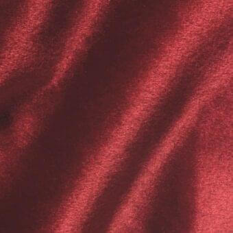 Brilliant Velour fabric VE16, deep red, dense pile with directional sheen creating diagonal stripes and a plush, granular texture.