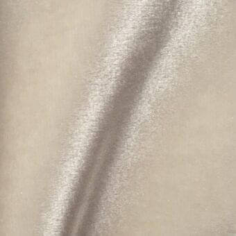 Brilliant Velour fabric swatch, warm beige color, with a directional sheen and vertical highlight band emphasizing the dense, plush texture.