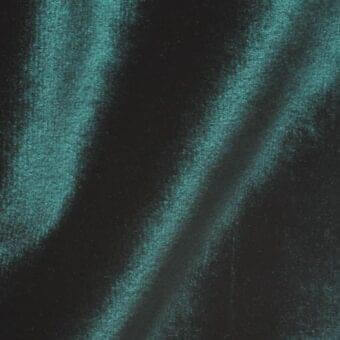 Textured teal and charcoal surface with vertical streaks, granular velvet-like texture, diffused lighting, and subtle tonal variations.