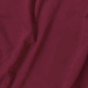 Burgundy fabric swatch with brushed texture, labeled “vismara eco nabuk,” draped to show matte finish and consistent color against a light gray backdrop.