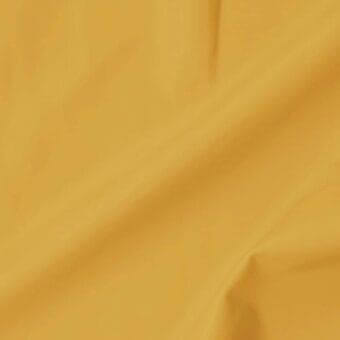 Extra leather swatch, muted mustard yellow, draped diagonally with soft folds displaying a matte texture and subtle sheen.